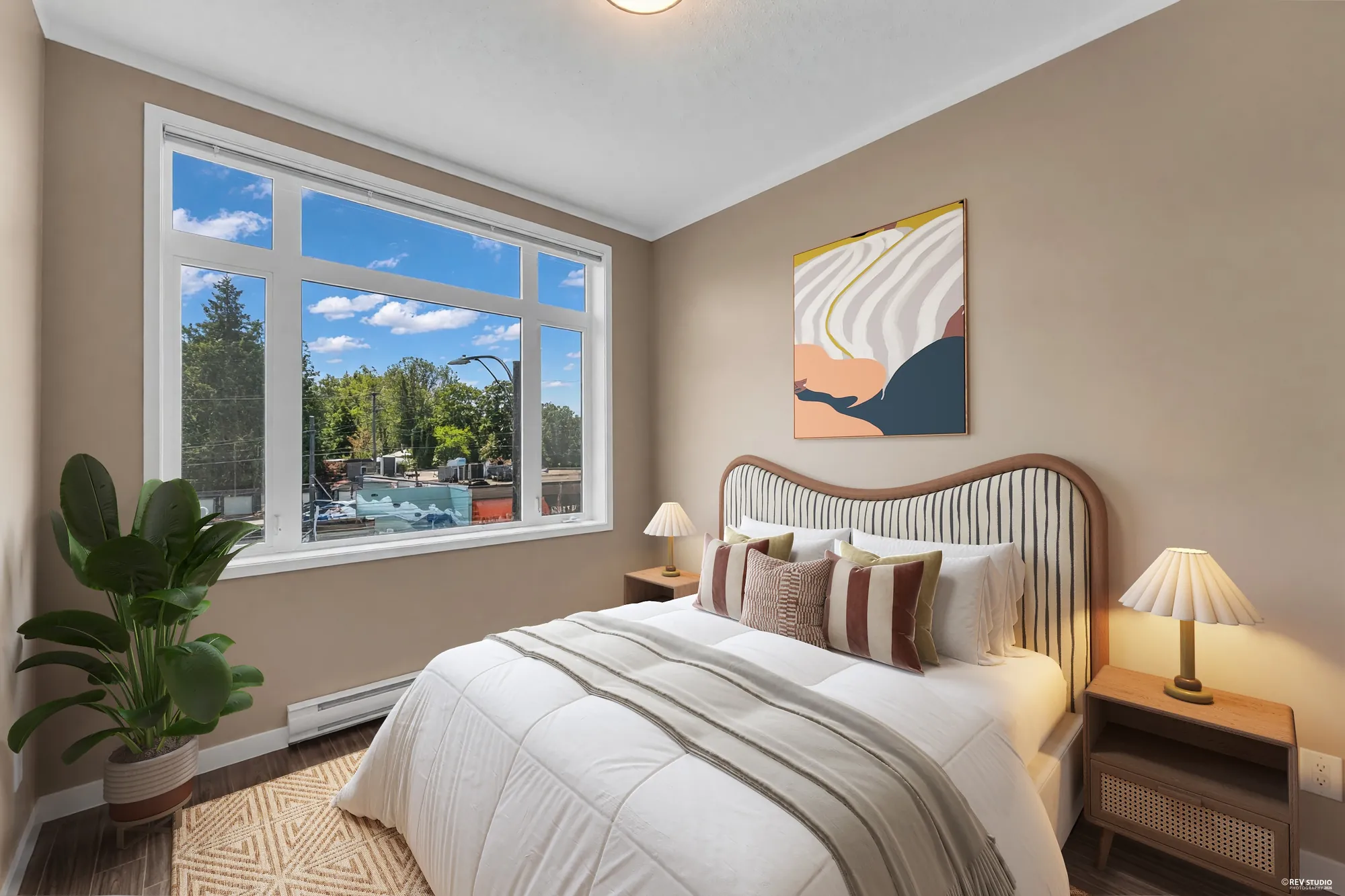 The second bedroom shown with furniture added digitally &mdash; a bed, nightstands and a rug