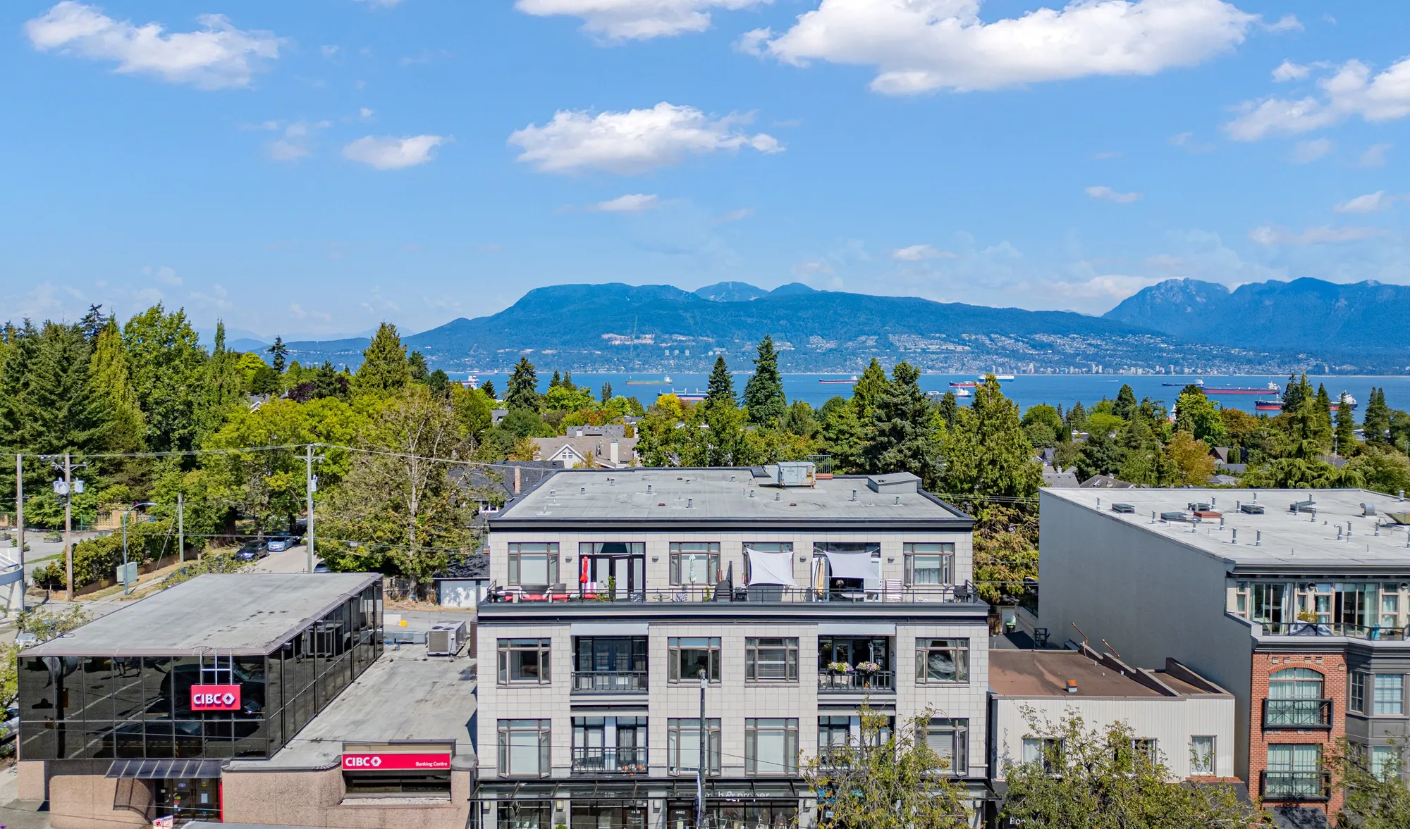 The Avenue at 4479 West 10th Avenue from the air, with English Bay and the North Shore mountains behind