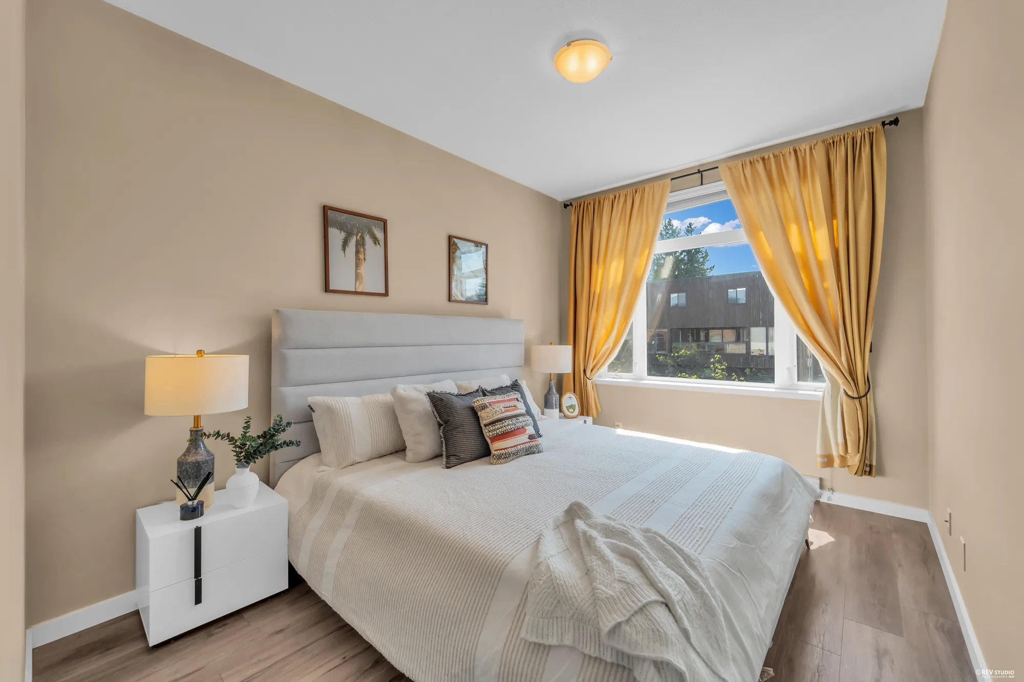 The primary bedroom with a window and curtains at the far end